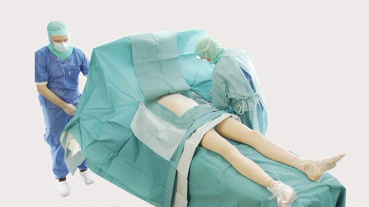a surgeon covering a patient with BARRIER cardiovascular drapes for an operation