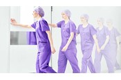 female nurse wearing Barrier a scrub suit enters a room